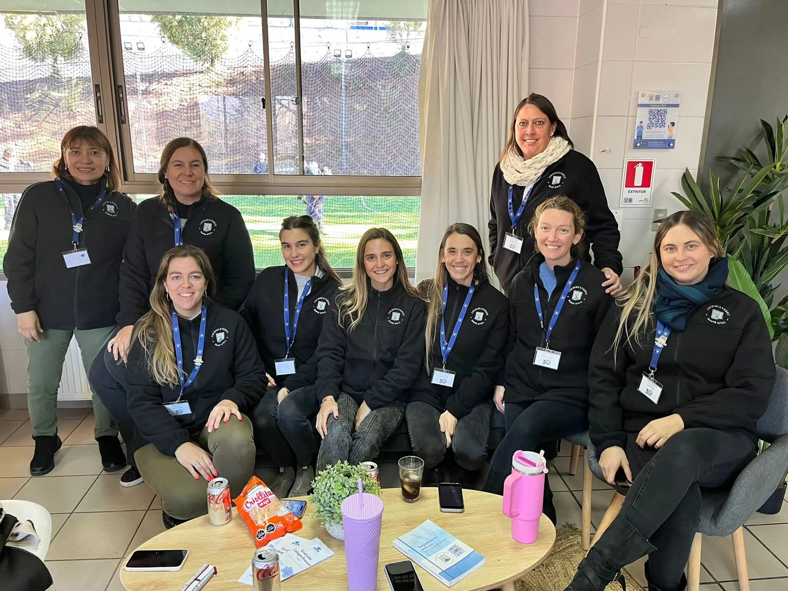 Equipo y comunidad del Colegio Everest posando con vestuario corporativo personalizado Kahlo